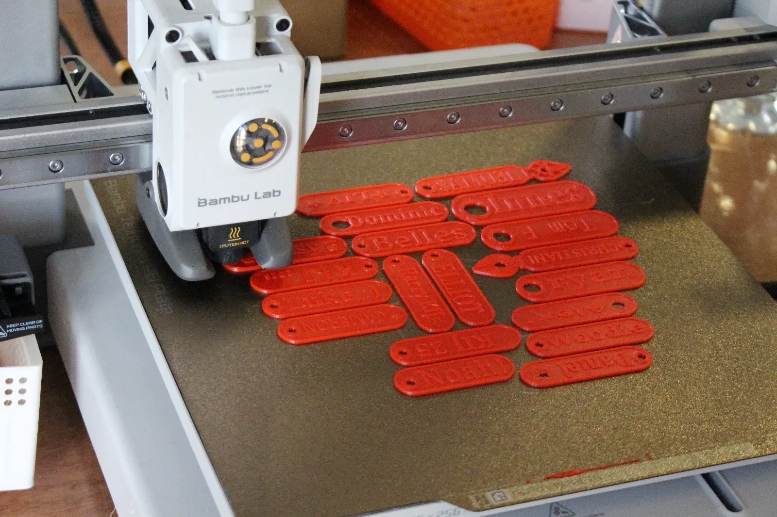 Freshly 3D printed name tags laid out on a table.